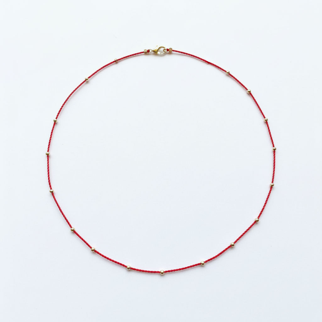 Red cord necklace circular on white background