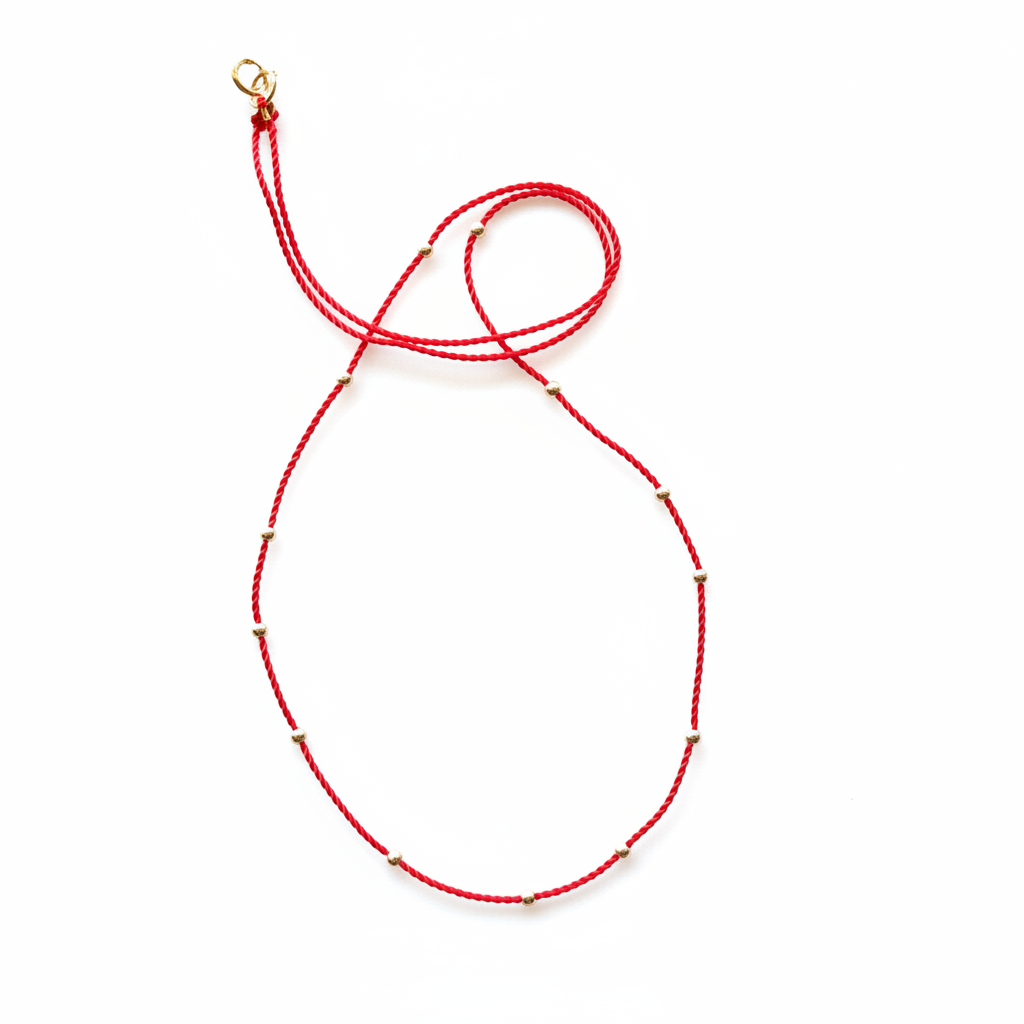 Red cord necklace on white background